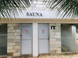 A building with a sign reading 'SAUNA' above two closed shuttered doors. - Lacqua diRoma RM Hospedagem (Caldas Novas)