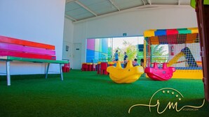 Un área de juegos infantiles con estructuras coloridas y un banco.