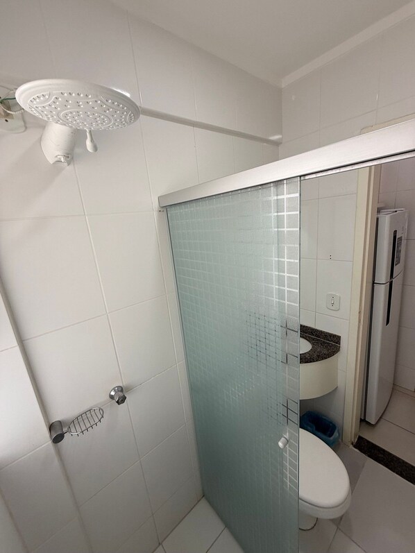 Un baño con ducha, inodoro y lavamanos.