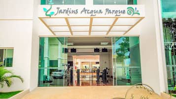 Entrada de um prédio com uma placa que diz 'Jardins Acqua Parque'.