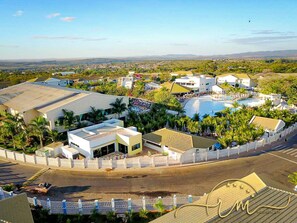 A resort with multiple buildings, a swimming pool, and a fenced area. - Lacqua diRoma RM Hospedagem (Caldas Novas)