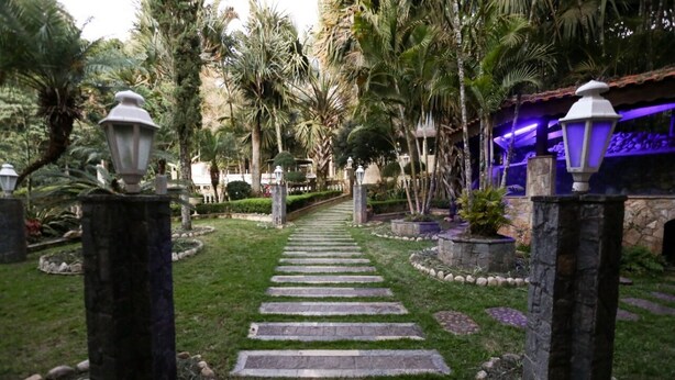 A pathway leading through a garden with palm trees and stone lanterns. - Chácara Bosque dos Pássaros - Santa Isabel (Santa Isabel)