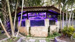 A stone structure with a tiled roof and a water feature. - Chácara Bosque dos Pássaros - Santa Isabel (Santa Isabel)