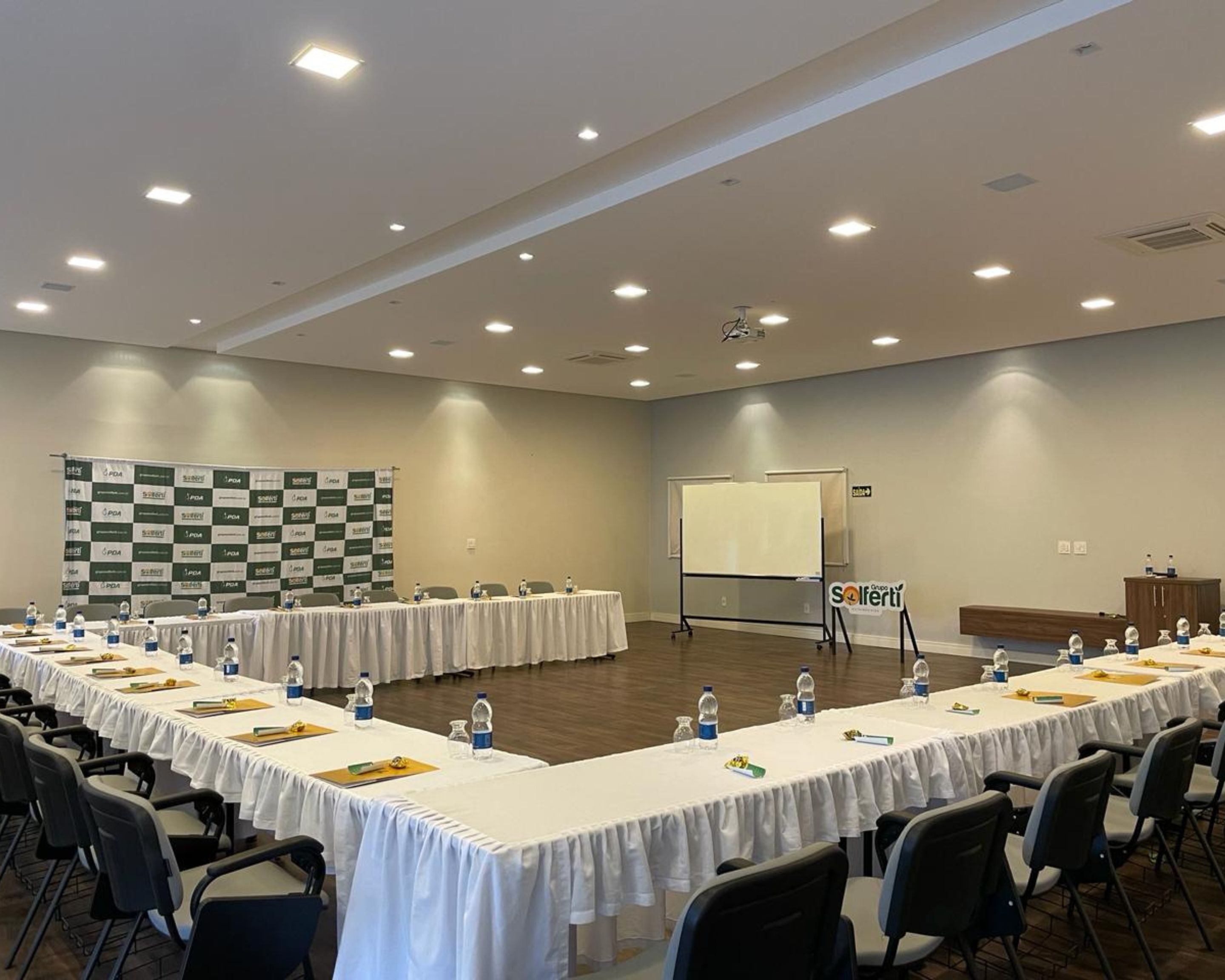 A conference room with long tables, chairs, and a whiteboard.