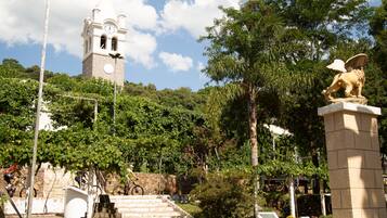 A plaza with a clock tower, steps leading up to it, and a statue of an eagle.