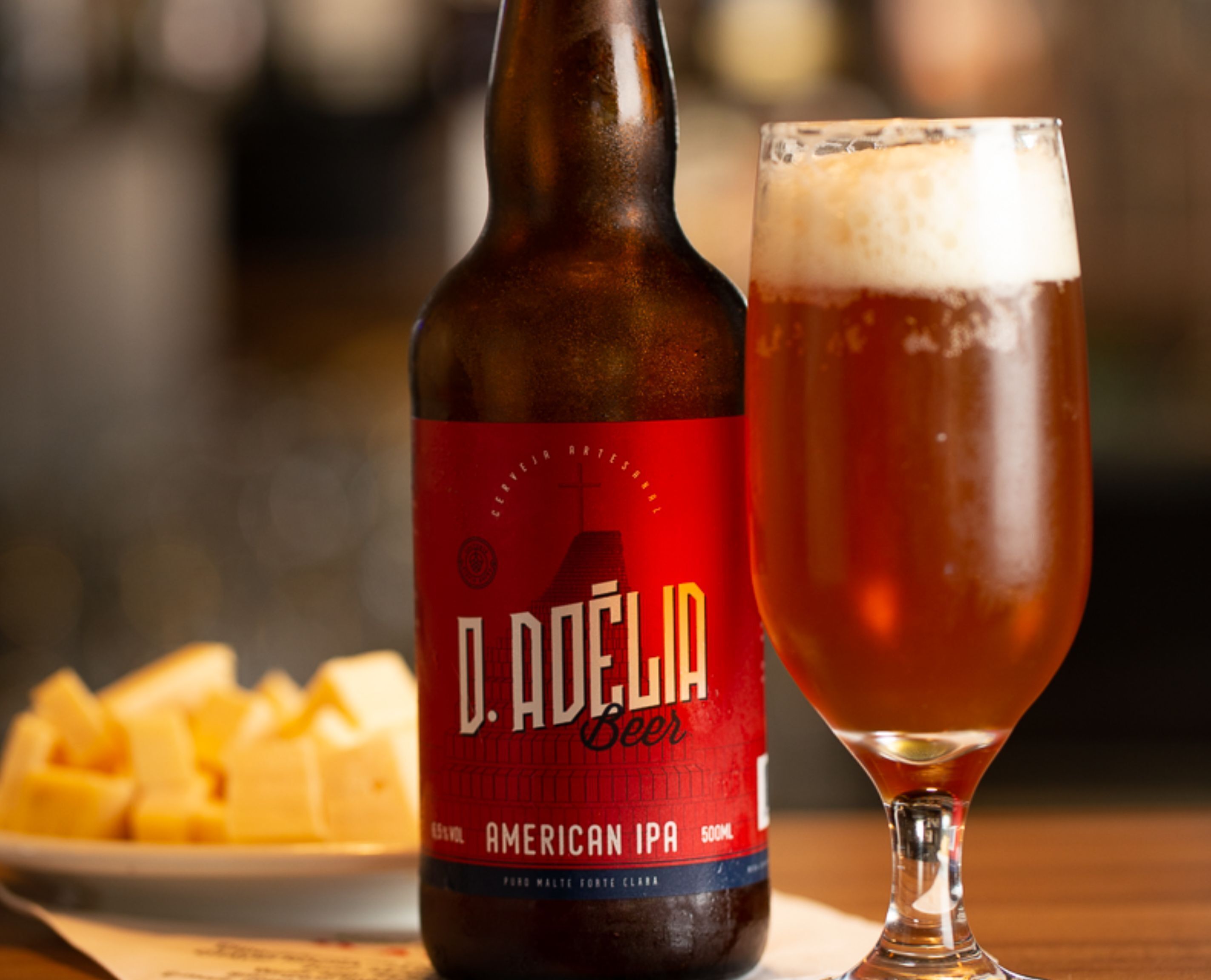 A bottle of D. Adelia beer and a glass of beer on a table.