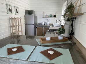 Modern kitchen with stainless steel appliances, oven, and gas stove, featuring a large island with additional workspace.
