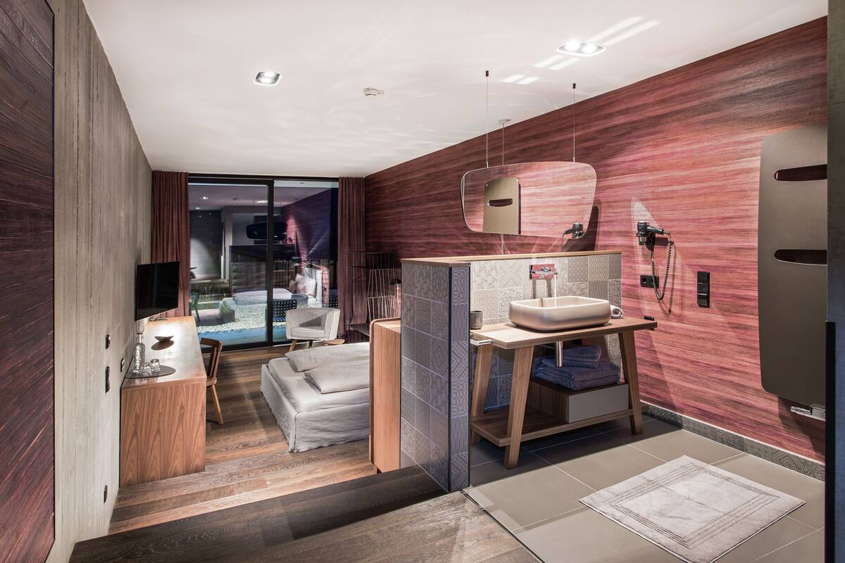 A modern bathroom with a large mirror, wooden vanity, and a glass shower enclosure.