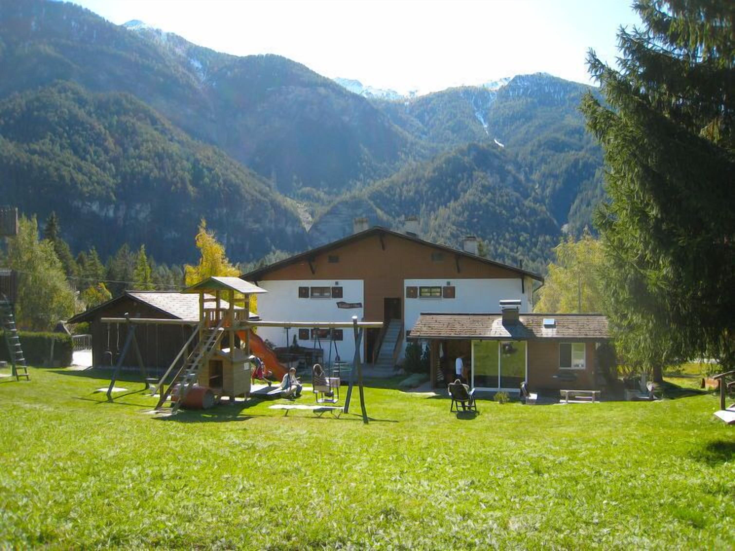 Un chalet doté d’un espace de jeux, d’un coin salon couvert et offrant une vue sur les montagnes.