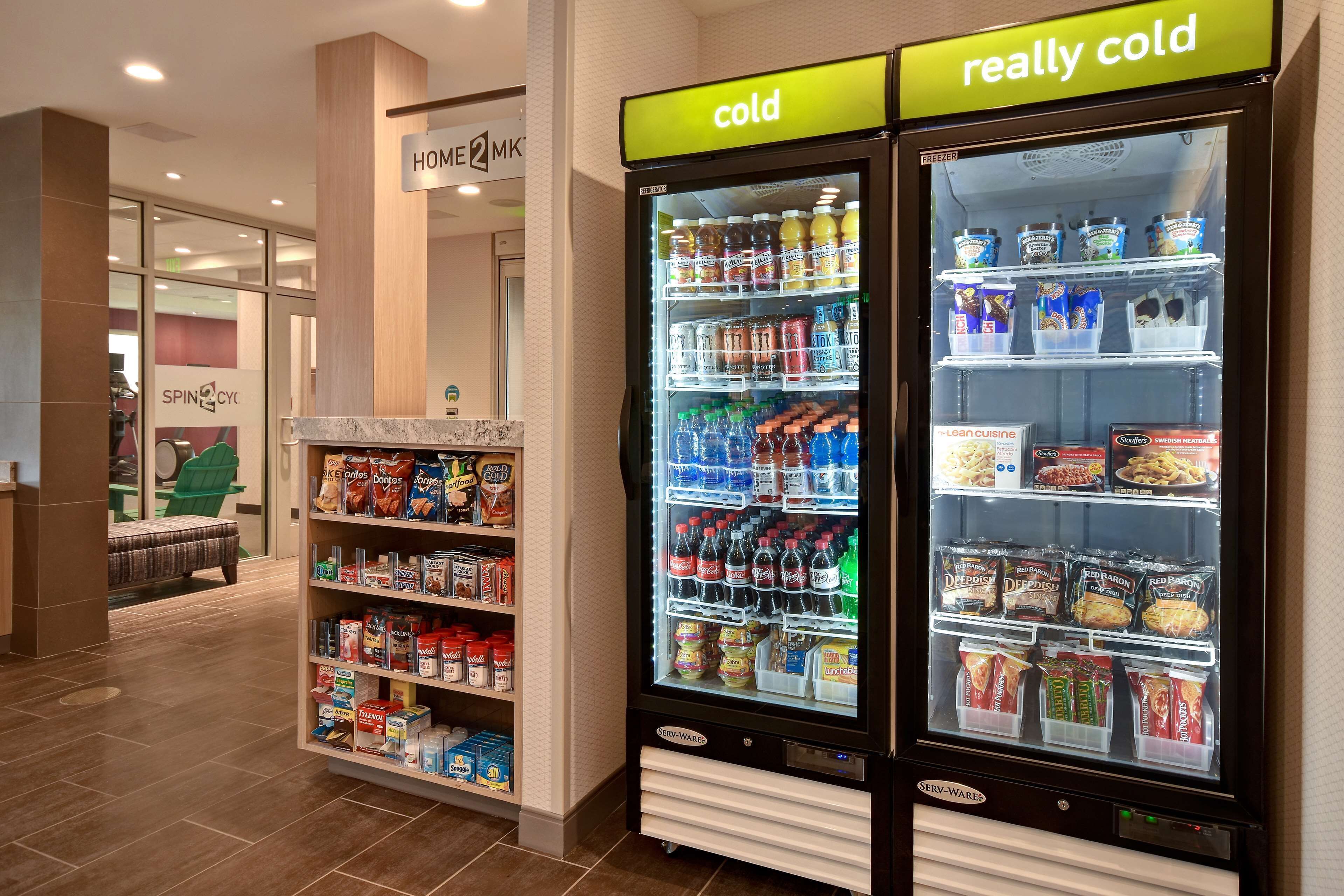 Un distributeur automatique avec une pancarte indiquant « très froid », rempli de boissons et d’en-cas.