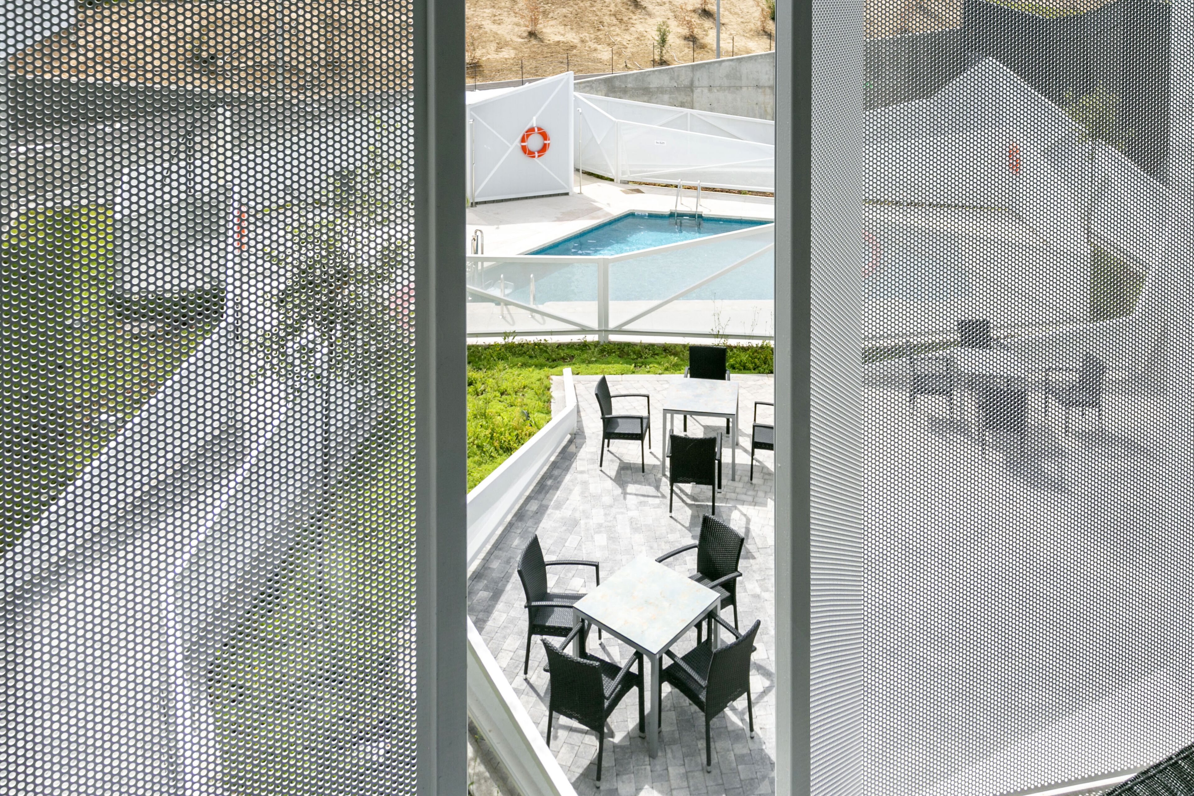 An outdoor pool area with a lifebuoy, surrounded by outdoor seating.