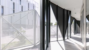 A modern interior with large windows, a geometric glass structure, and a clean, minimalist design. - Hampton by Hilton Alcobendas Madrid (Alcobendas)