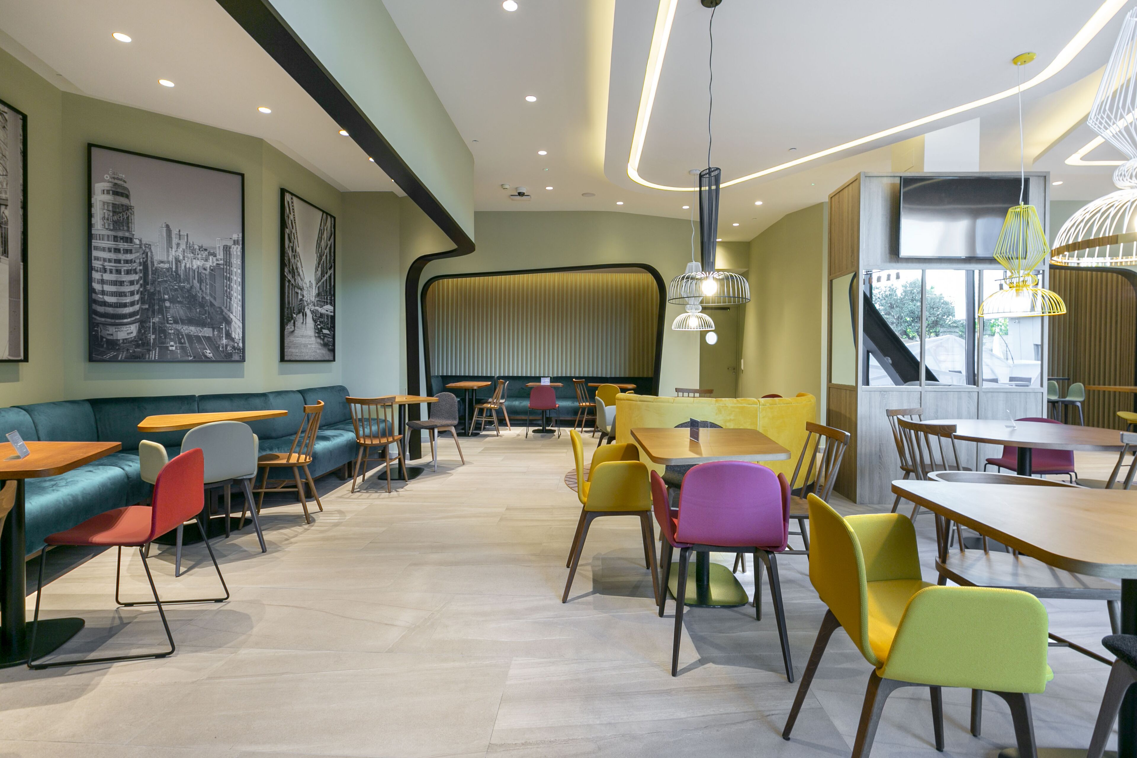 En modern restaurang med en inredning som erbjuder olika typer av sittplatser, inklusive bord, stolar och en soffa.