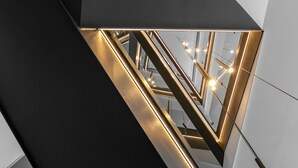 A modern interior with geometric lighting fixtures and reflective surfaces. - Hampton by Hilton Alcobendas Madrid (Alcobendas)