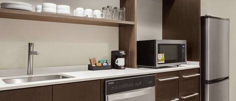 A modern kitchen with a stainless steel refrigerator, a built-in microwave, and a dishwasher.