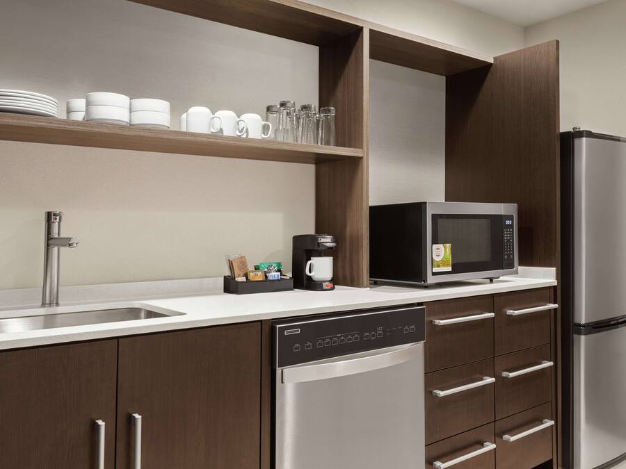 A modern kitchen with a stainless steel refrigerator, a built-in microwave, and a dishwasher.