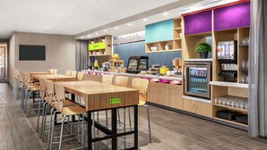 Een modern restaurant met een lange toonbank, verschillende zithoeken en een ruime keuze aan eten en drinken.