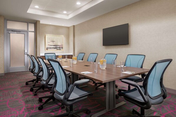 A conference room with a long table, multiple chairs, and a flat-screen TV on the wall. - Home2 Suites by Hilton Ridley Park Philadelphia Airport South (Ridley Park)