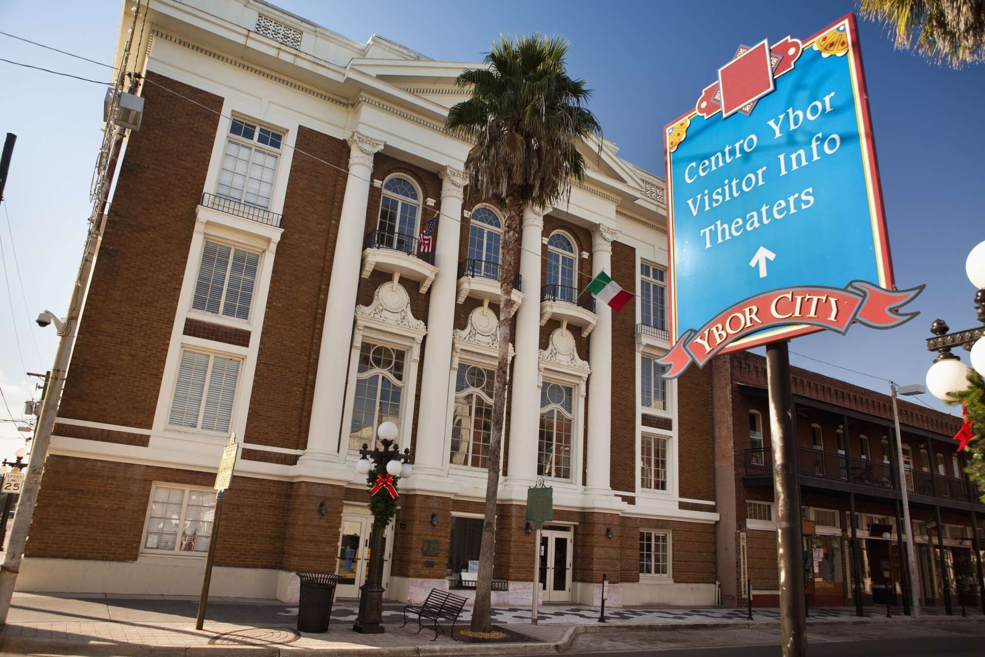 Un edificio histórico con un letrero que indica información para visitantes y teatros.