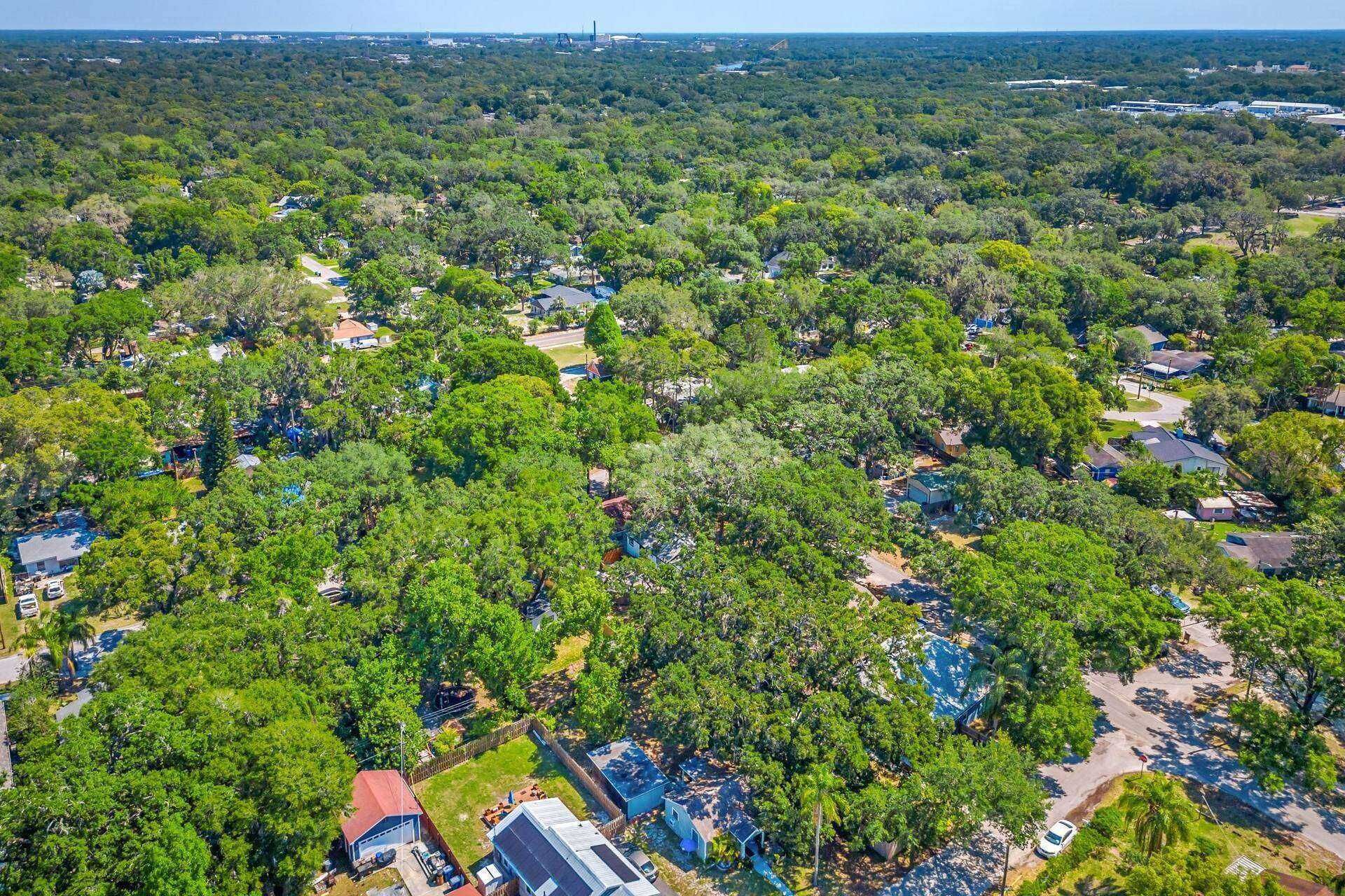 Vue aérienne d’un quartier résidentiel où les maisons sont entourées d’une végétation luxuriante.