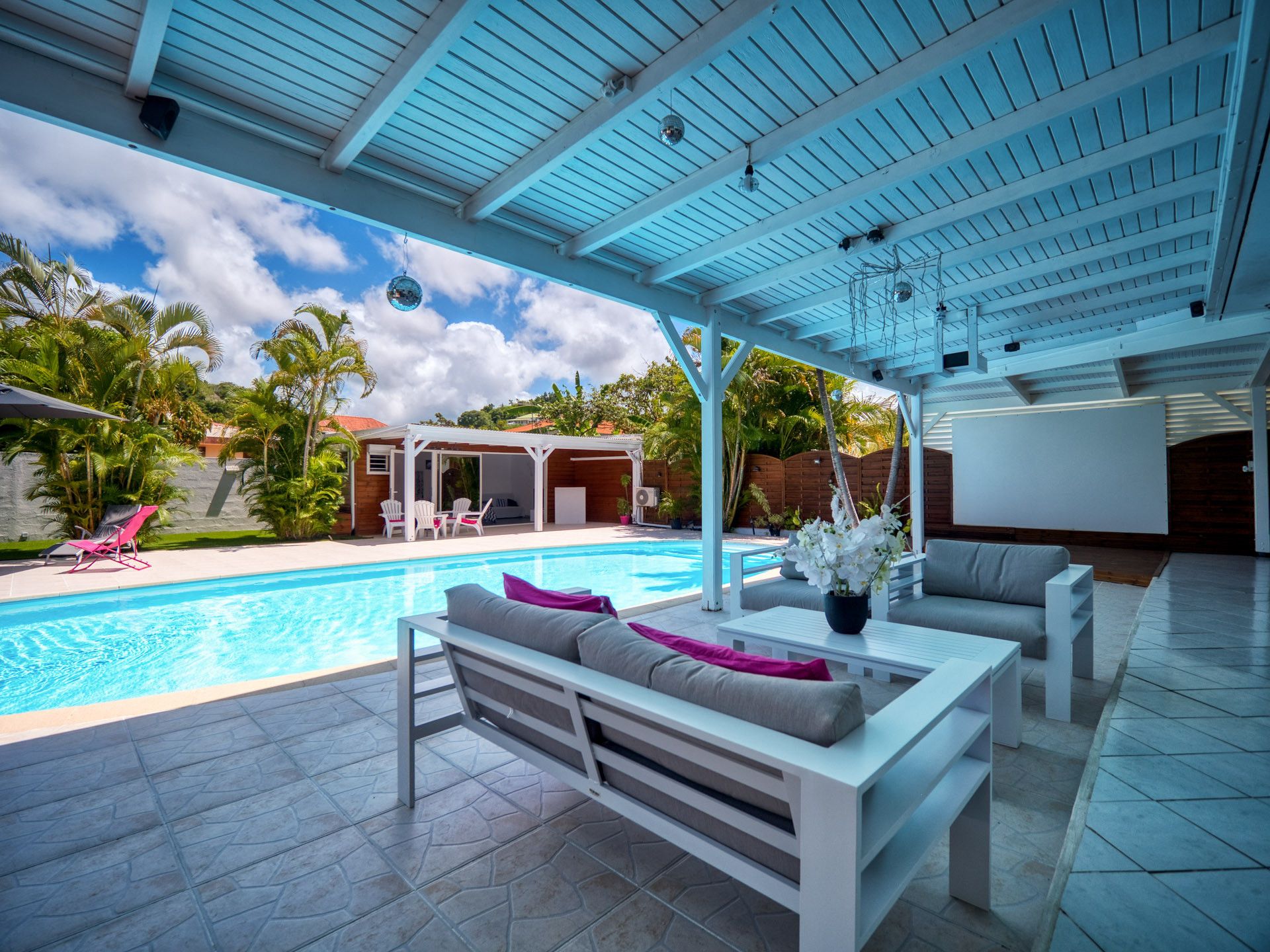 Un espace extérieur abrité avec une piscine, des sièges et une vue sur la piscine.