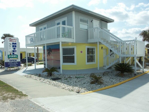 A motel with a two-story structure, a balcony, and a beach-themed mural. - Flagler Beach Motel and Vacation Rentals (Flagler Beach)