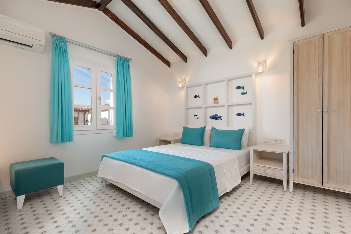 Ein Schlafzimmer mit einem Bett, einem Nachttisch, einem Holzschrank und einem Fenster mit Vorhängen.