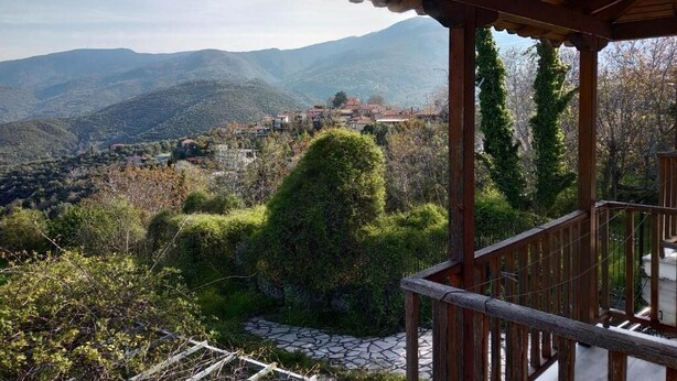 Un pabellón de madera con vistas a un paisaje montañoso.