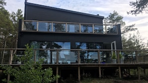 A modern two-story house with large windows and a balcony. - Comfortable seaside villa in the Nordic Archipelago by four star resort (Geta)