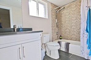 Tina con regadera, secadora de cabello, toallas, jabón 