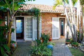A house with a tiled roof, brick walls, and a paved courtyard. - Pousada Lua do Pontal (Florianópolis)
