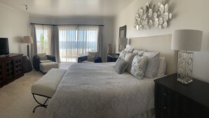 A spacious bedroom with a large bed, a TV, and a view of the beach through the windows. - Triple En-suite on the beach at Las Mananitas  (San Jose del cabo)