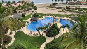 A resort with a large swimming pool, palm trees, and a beach view. - Triple En-suite on the beach at Las Mananitas  (San Jose del cabo)