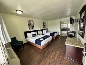 A hotel room with two beds, a desk, a chair, and a kitchenette. - QUINTA SAN CARLOS INN (Piedras Negras)