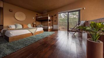 A bedroom with a bunk bed, a balcony with chairs, and a large potted plant.