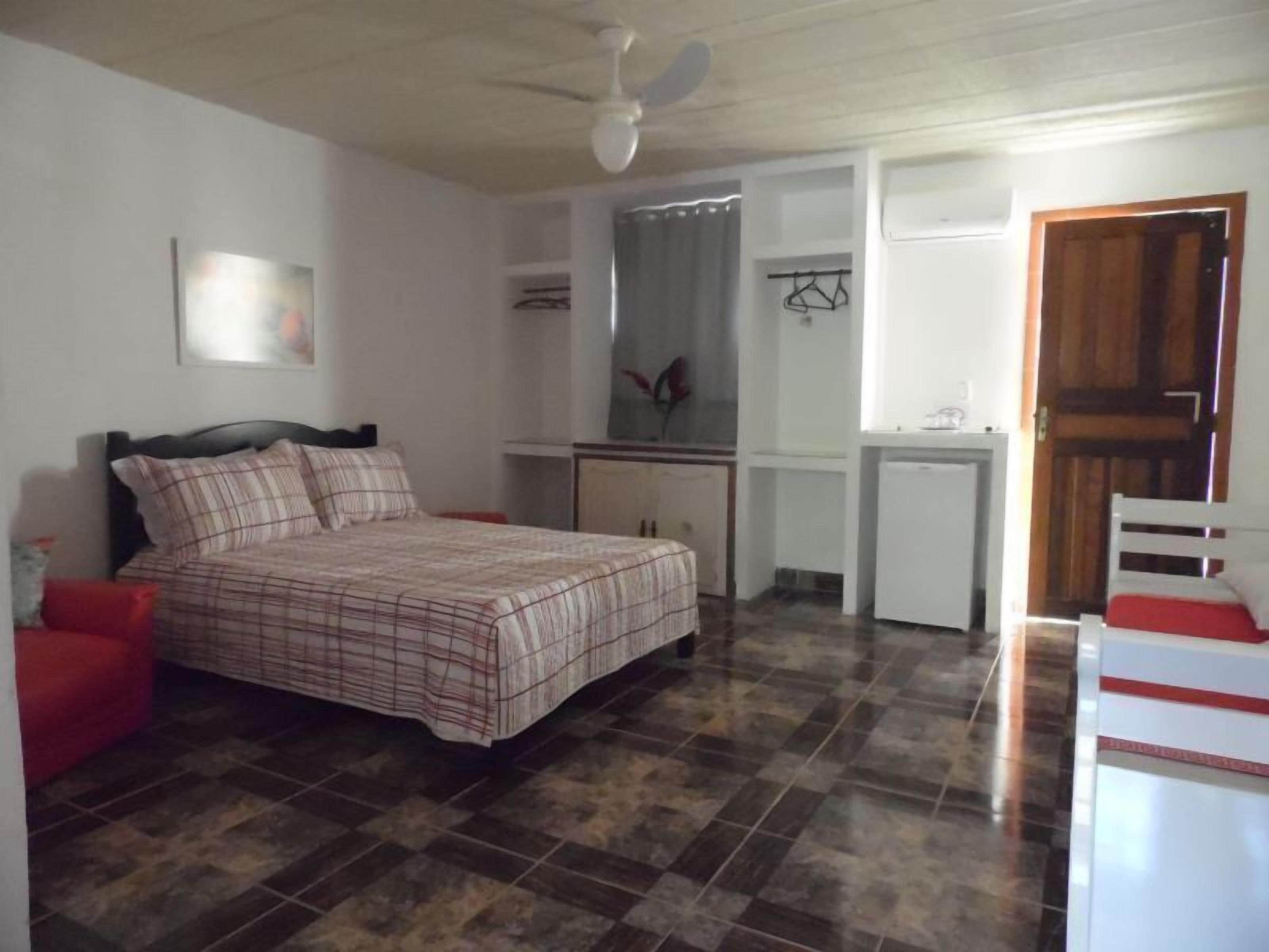Un dormitorio con cama, escritorio, silla y armario.