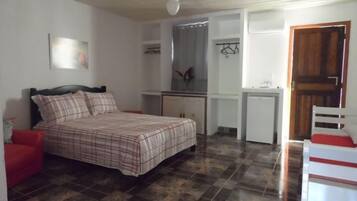 Un dormitorio con cama, escritorio, silla y armario.