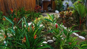 A garden with various plants and a swing chair. - La Fortuna Lodge by Treebu Hotels (La Fortuna)