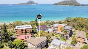 A coastal hotel with multiple buildings, a swimming pool, and a view of the ocean and nearby islands. - Endeavour, 3/13 Ondine Cl - large three bedroom unit with filtered water views (Nelson Bay)