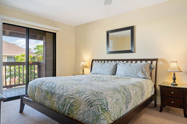 Quarto com cama, duas mesas de cabeceira, um criado-mudo, janela com vista e ventilador de teto.
