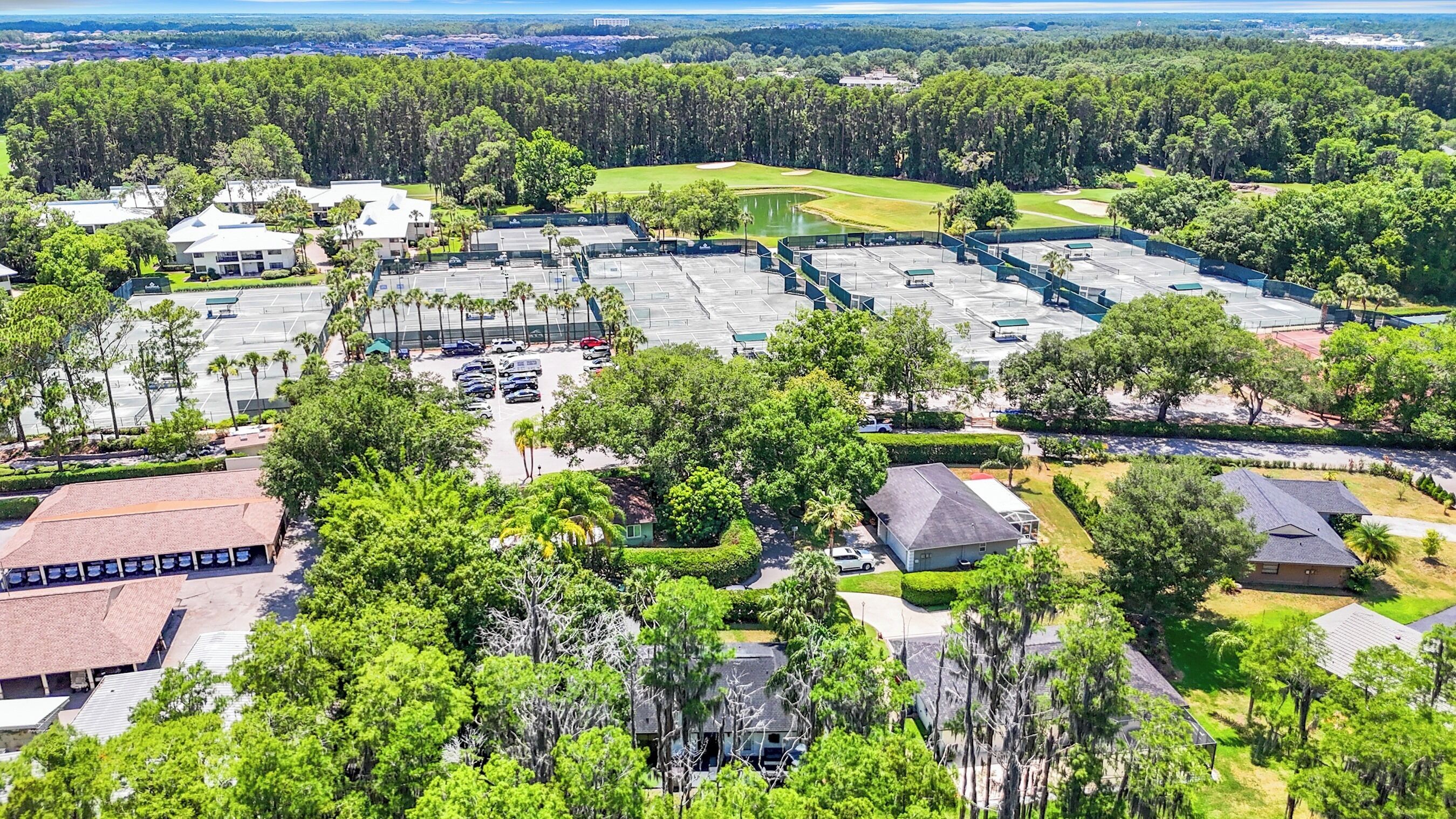 Una zona residencial con varias casas, un estacionamiento y un campo de golf al fondo.