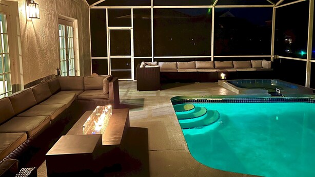 An outdoor pool area with a hot tub, a sofa, and a table. - DisneyMansion by AmericanVacationLiving 11BR (Davenport)