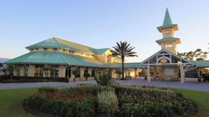 A large building with a green roof and a clock tower.