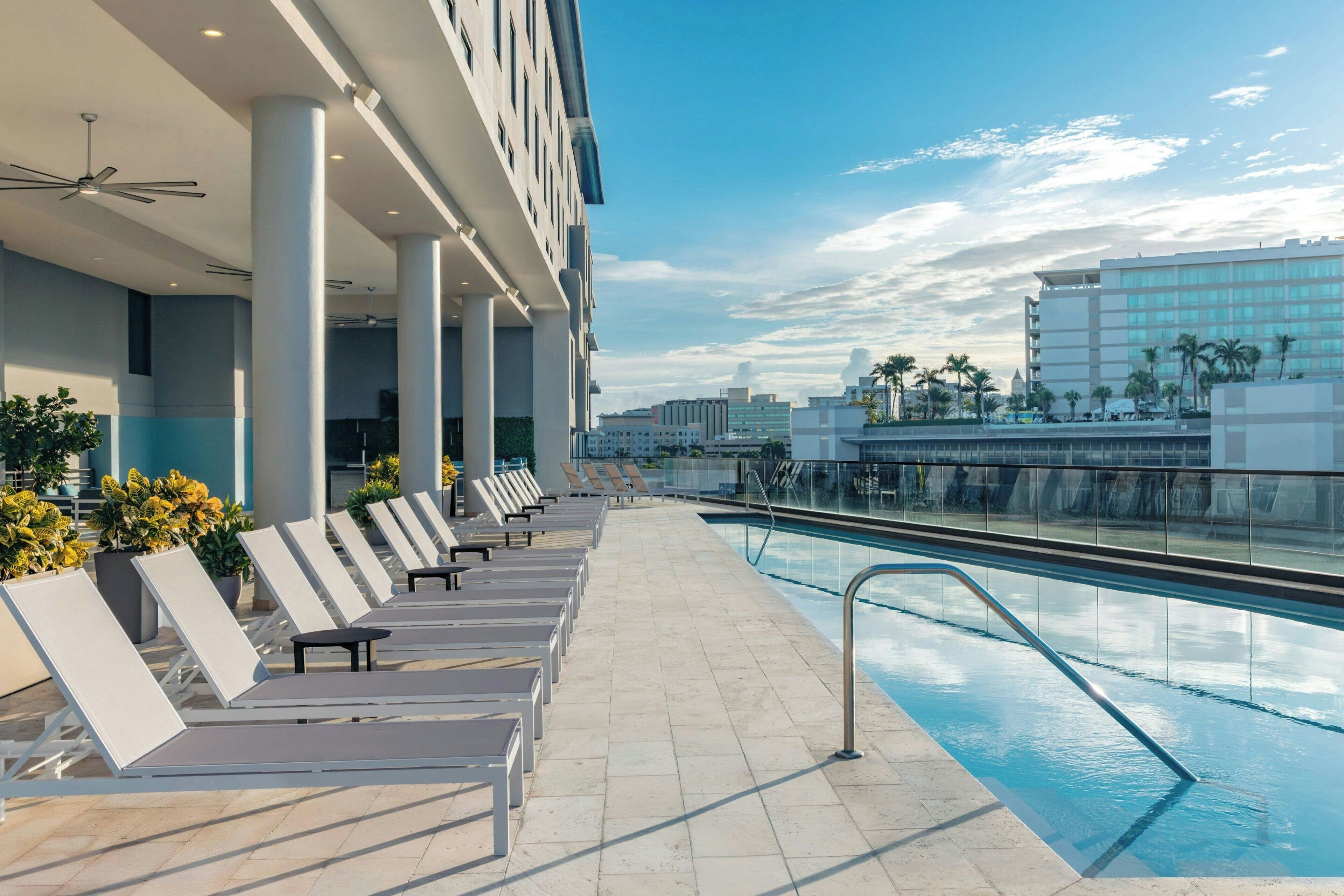 Un área junto a la piscina con sillones de descanso y una piscina.