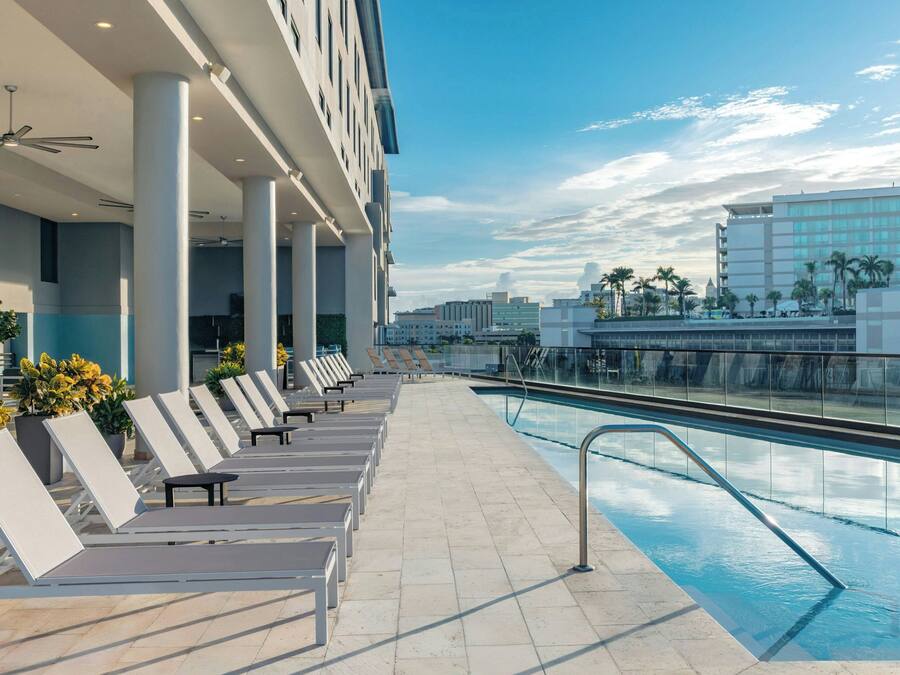 Un área junto a la piscina con sillones de descanso y una piscina.