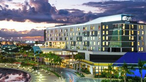 Un hotel moderno con techo plano, varios pisos y un llamativo letrero 'aloft'.