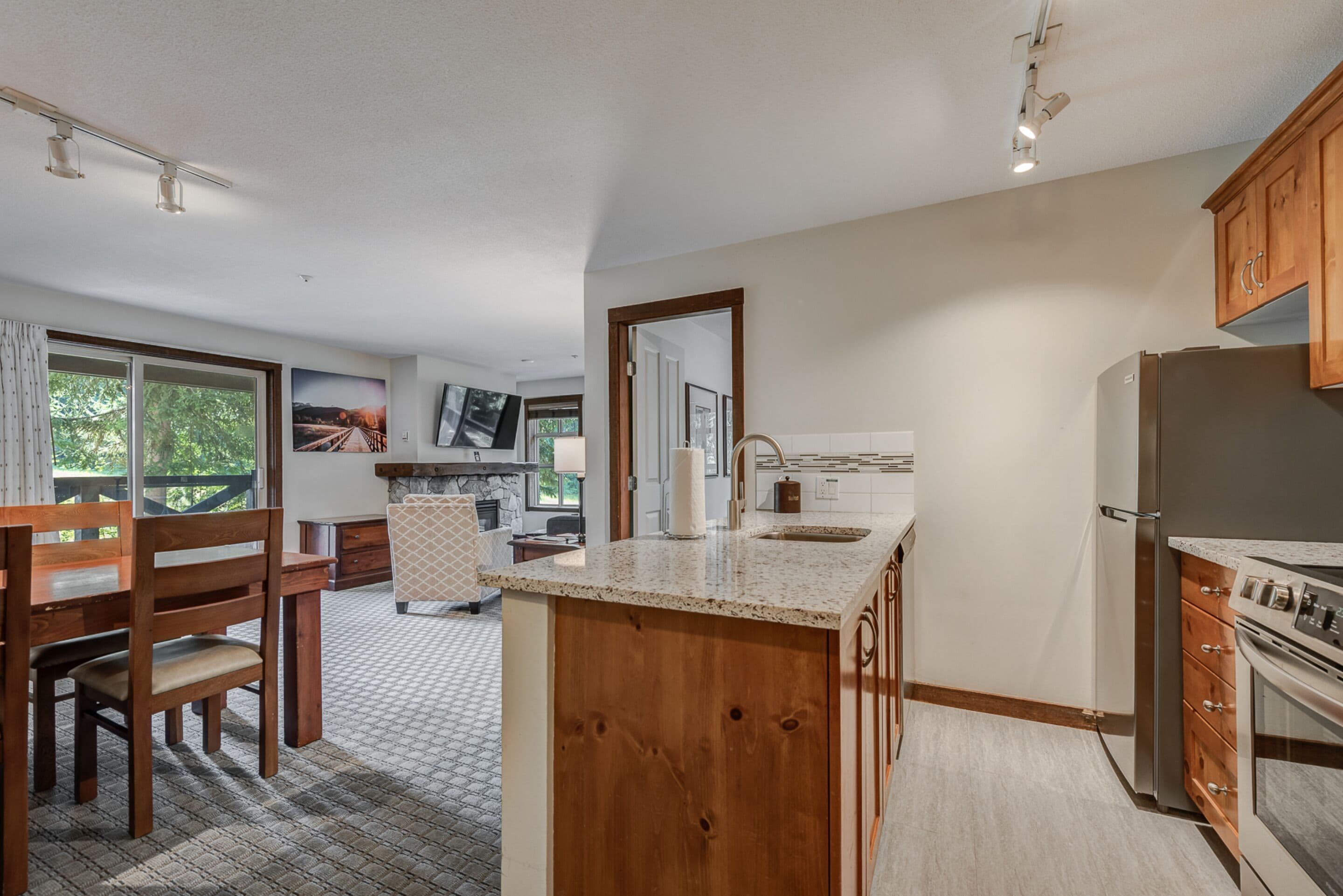A modern kitchen with wooden cabinetry, a granite countertop, and stainless steel appliances.