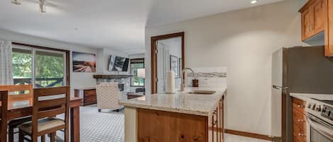 A modern kitchen with wooden cabinetry, a granite countertop, and stainless steel appliances.