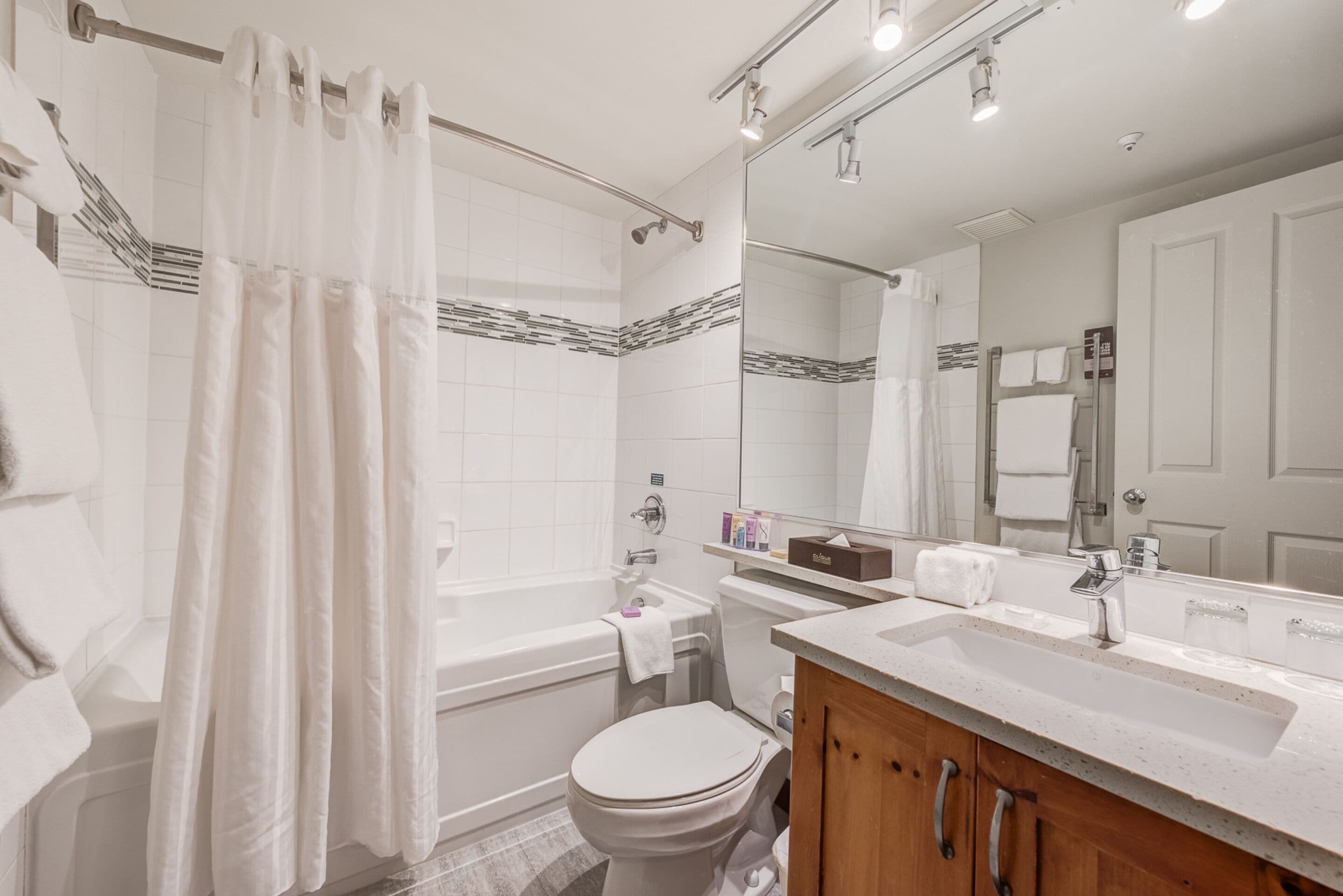 A modern bathroom with a bathtub, toilet, and sink.