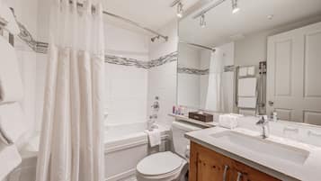 A modern bathroom with a bathtub, toilet, and sink.